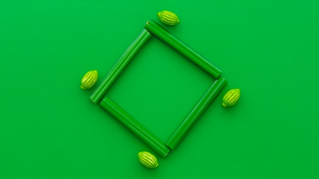 Vista de ángulo alto de regaliz y caramelos de limón sobre fondo verde