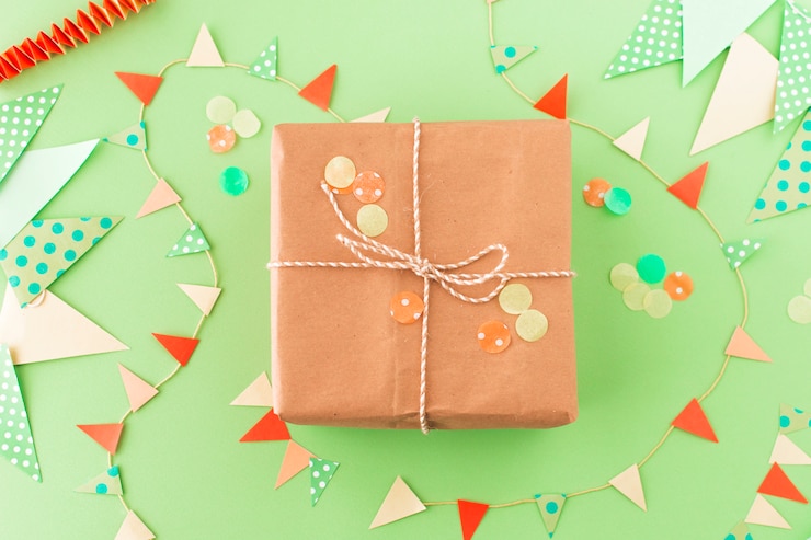 Foto gratuito vista de ángulo alto de regalo de cumpleaños y bunting sobre fondo verde