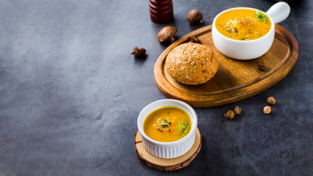 Vista de ángulo alto de sopa de calabaza en tablero de madera con espacio de copia