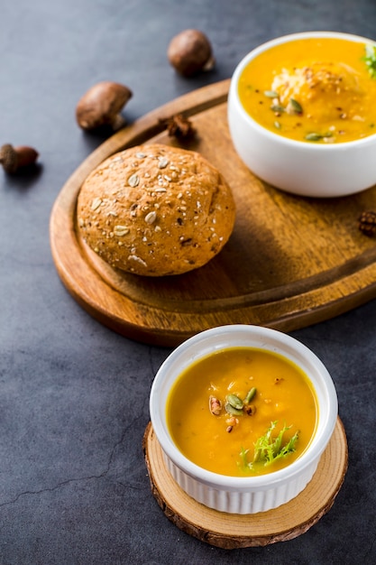 Vista de ángulo alto de sopa de calabaza en tablero de madera