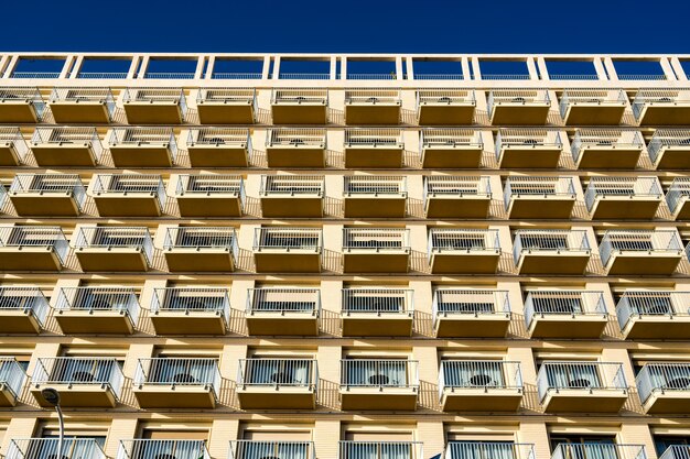 Vista de ángulo bajo del edificio moderno con balcones contra el cielo azul