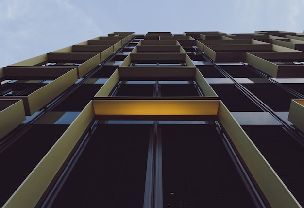 Foto gratuita vista de ángulo bajo de un edificio moderno con ventanas de vidrio bajo la luz del sol