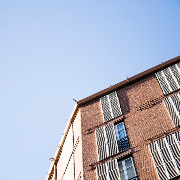 Vista de ángulo bajo de un edificio con ventanas contra el cielo azul