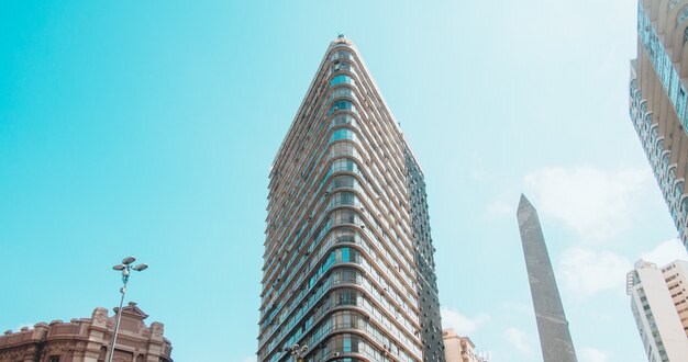 Vista de ángulo bajo de edificios modernos bajo un cielo azul y la luz del sol