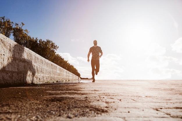 Vista de ángulo bajo de un hombre deportivo corriendo