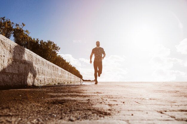 Vista de ángulo bajo de un hombre deportivo corriendo