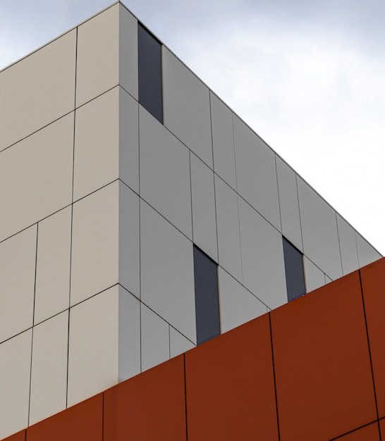 Vista de ángulo bajo de un moderno edificio blanco y naranja bajo el cielo brillante