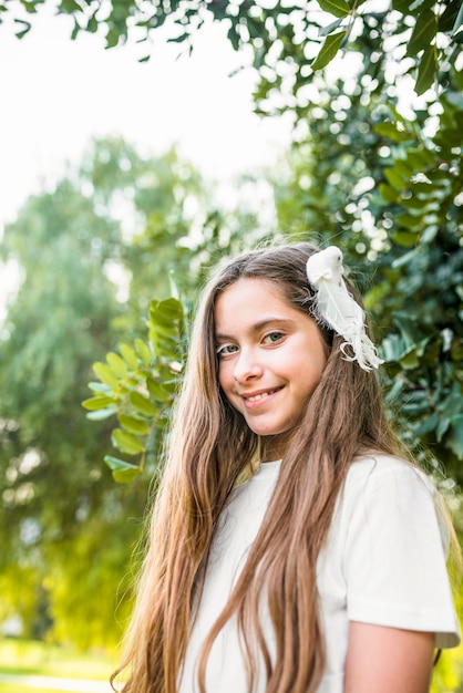 Foto gratuita vista de ángulo bajo de una niña bonita mirando a cámara