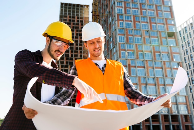 Vista de ángulo bajo de tiro medio del ingeniero y arquitecto que supervisa la construcción