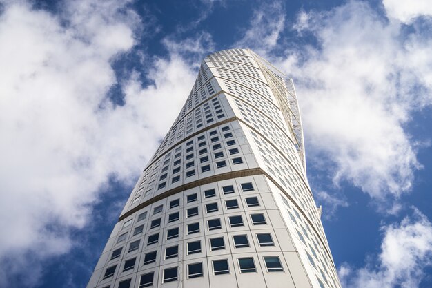 Vista de ángulo bajo el Turning Torso bajo un cielo azul y la luz del sol en Malmo en Suecia