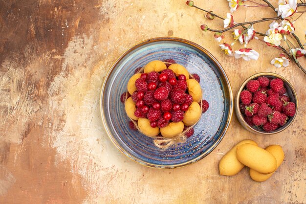 Foto gratuita vista anterior de bizcocho recién horneado con frutas y galletas en la tabla de colores mezclados