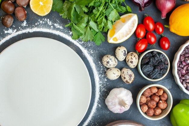 Vista anterior de la cena cocinando con huevos, verduras frescas, paquetes verdes sobre azul oscuro