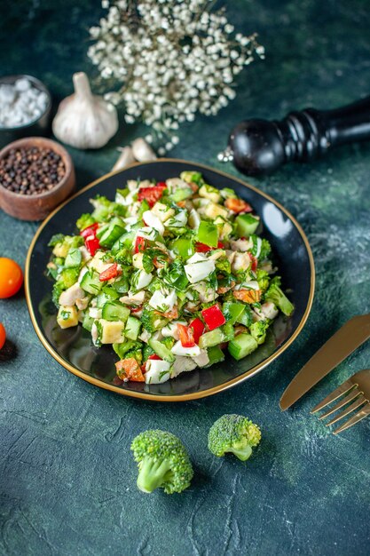 Vista anterior ensalada de verduras se compone de queso de pepino y tomates sobre fondo azul oscuro