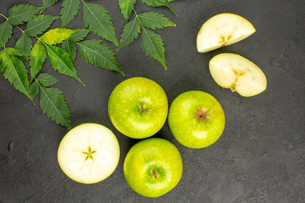 Foto gratuita vista anterior de manzanas verdes frescas enteras y picadas y menta sobre fondo negro