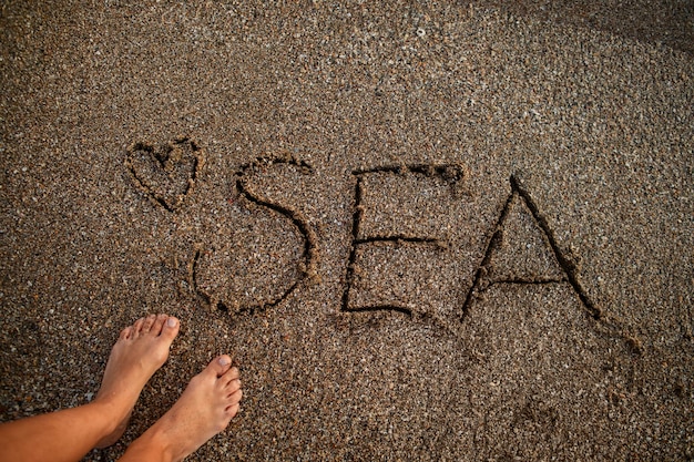 Foto gratuita vista de la arena de la playa en verano con un mensaje escrito en ella