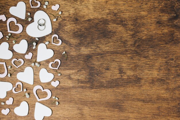 Una vista desde arriba de los anillos de bodas de plata en forma de corazón sobre el fondo de madera