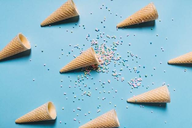 Foto gratuita la vista de arriba de colorido asperja con los conos de la galleta dispuestos en fondo azul