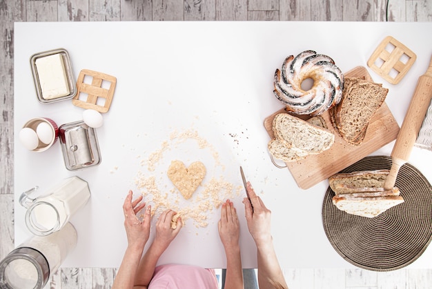 Foto gratuita la vista desde arriba. mamá e hija preparan pasteles en la cocina.