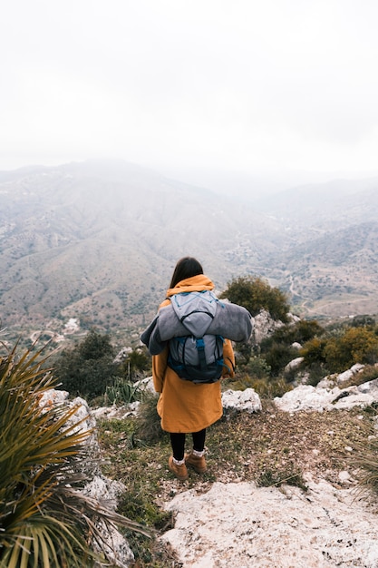 Una vista desde arriba de una mujer joven con su mochila con vistas a la montaña