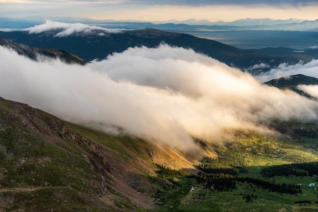 Vista del atardecer con cordilleras y nubes.