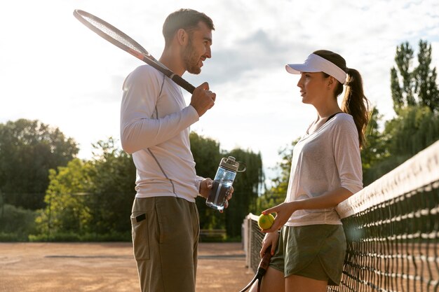 Vista baja pareja en cancha de tenis