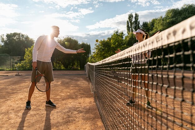 Vista baja pareja jugando tenis