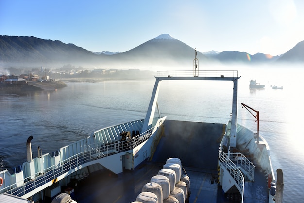 Vista brumosa del lago y las montañas desde el barco