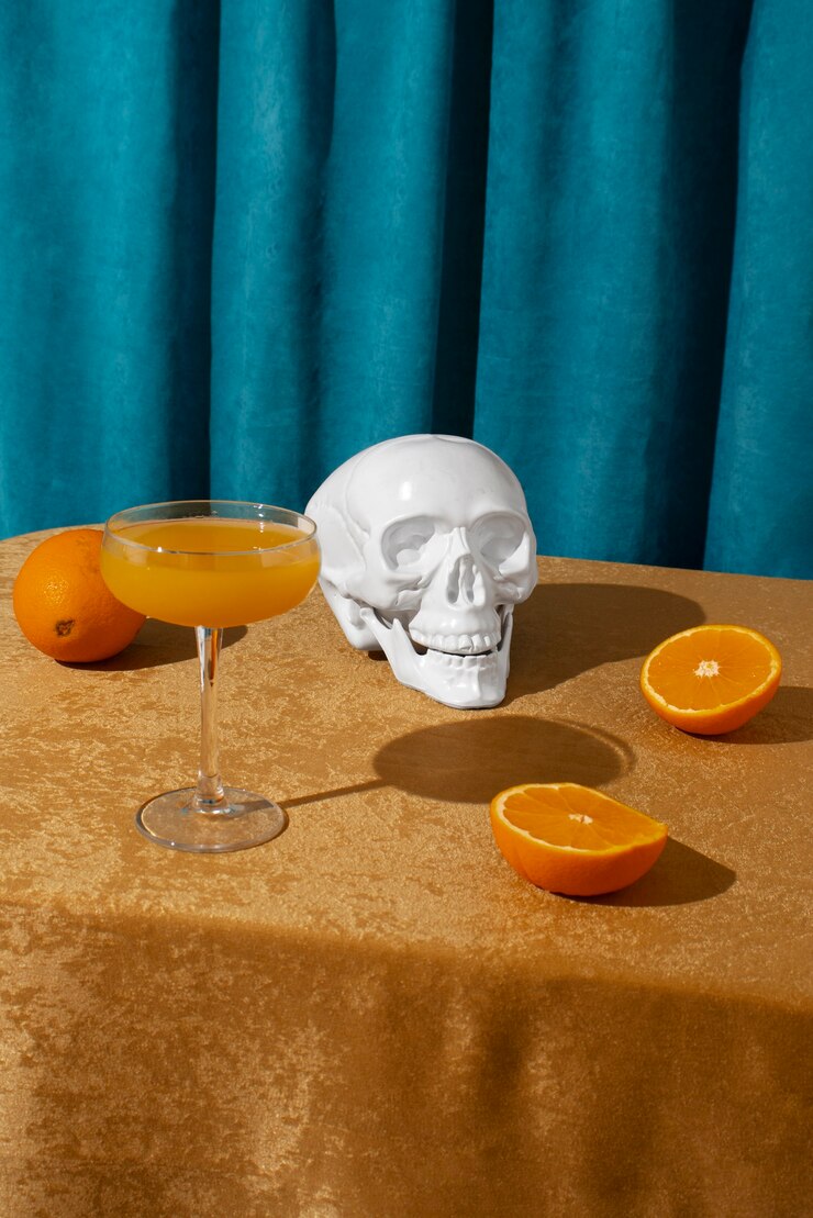 Foto gratuito vista de calavera blanca con cóctel de cítricos.