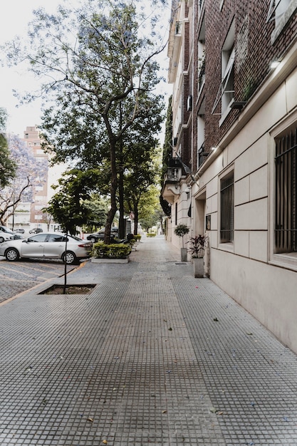 Vista a la calle con edificio y coches aparcados.