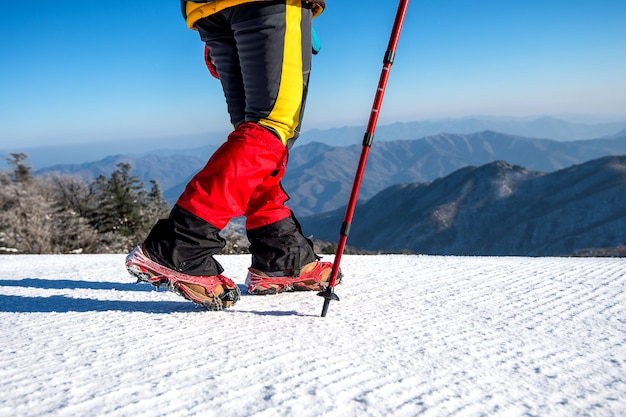 Vista de caminar sobre la nieve con raquetas de nieve y picos de zapatos en invierno