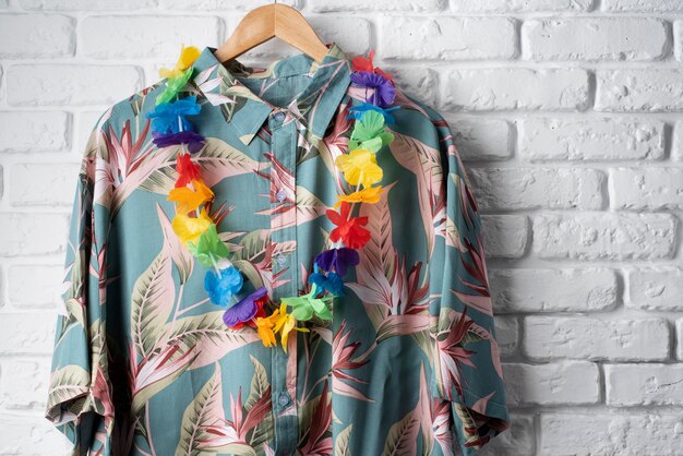 Vista de camisa hawaiana en percha con guirnalda