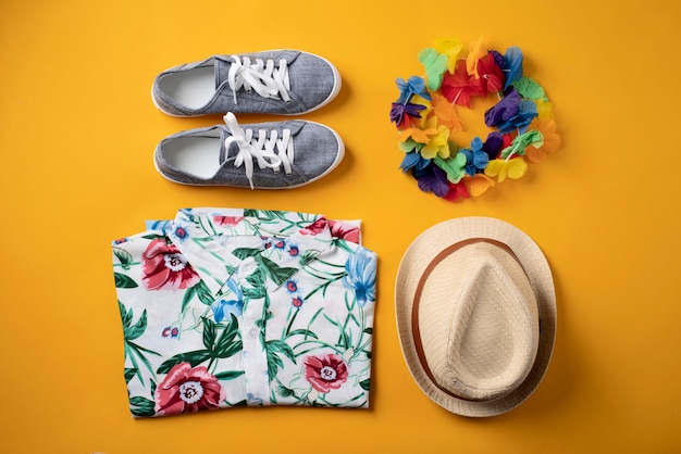 Vista de camisa hawaiana con zapatillas y sombrero.