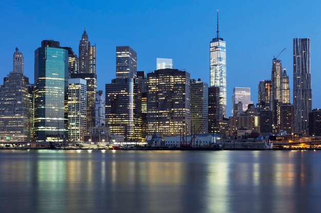 Vista del centro de Manhattan de Nueva York al anochecer con rascacielos iluminados sobre East River