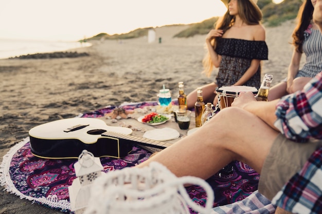 Foto gratuita vista de cerca de amigos sentados por la playa