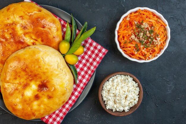 Vista de cerca de deliciosos kumquats pasteles recién horneados con tallo en rojo despojado de toalla y ensalada de queso en blackground oscuro