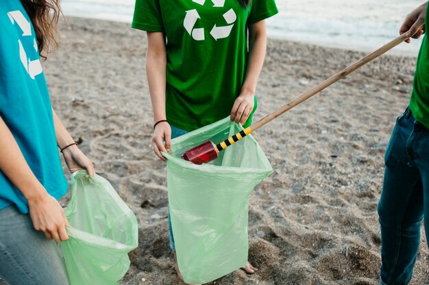 Vista de cerca de grupo de voluntarios recogiendo basura en la playa