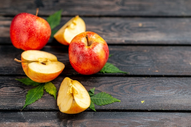 Foto gratuita vista de cerca de manzanas y hojas rojas frescas picadas y enteras naturales sobre fondo negro