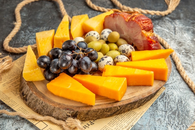 Vista de cerca de la mejor merienda con diversas frutas y alimentos en una cuerda de bandeja marrón de madera en un periódico viejo