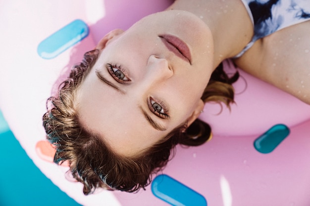 Vista de cerca de mujer en flotador en piscina