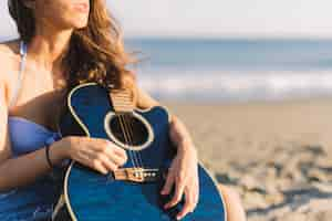 Foto gratuita vista de cerca de mujer con guitarra azul