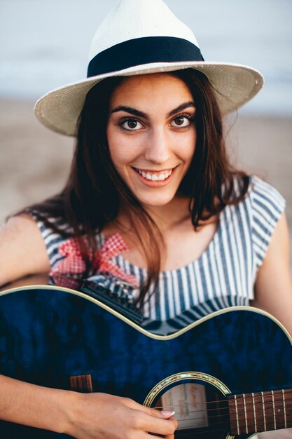 Vista de cerca de mujer con guitarra en la playa