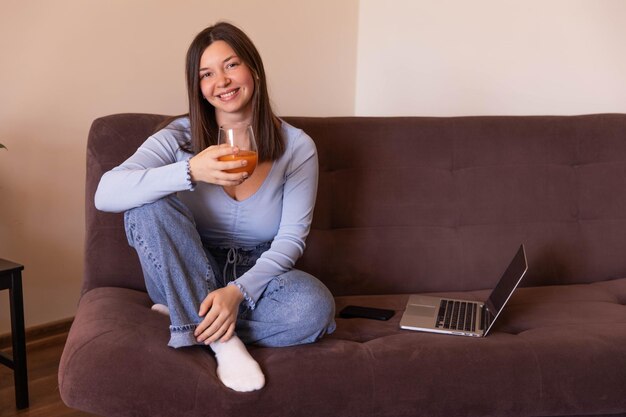 Vista de cerca de una mujer hermosa mirando a la cámara y sonriendo y relajándose en casa