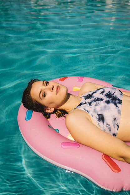 Vista de cerca de mujer joven en flotador en piscina