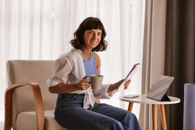 Vista de cerca de una mujer de negocios caucásica sentada en una silla sonriendo a la cámara