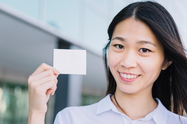 Vista de cerca de mujer de negocios enseñando tarjeta de visita