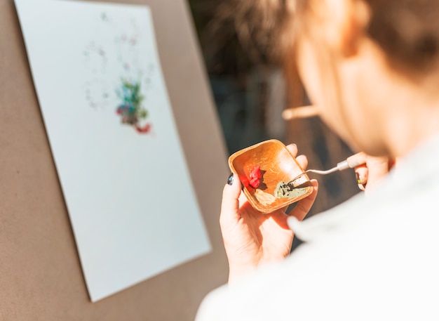 Vista de cerca de mujer pintando al aire libre