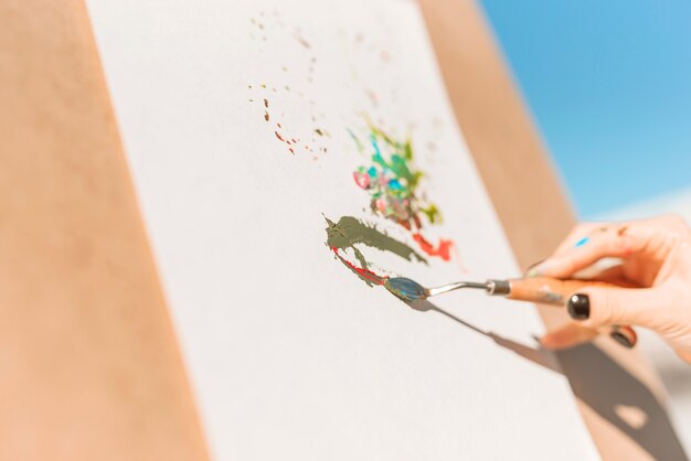 Vista de cerca de mujer pintando al aire libre