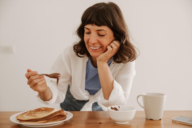 Vista de cerca de una mujer sonriente probando comida