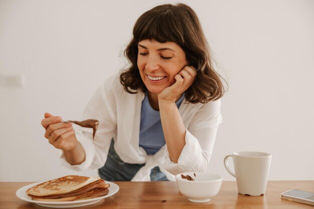 Vista de cerca de una mujer sonriente probando comida