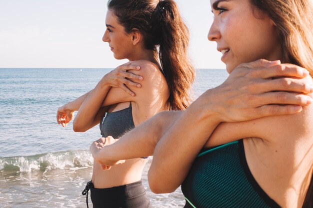 Vista de cerca de mujeres estirando brazos